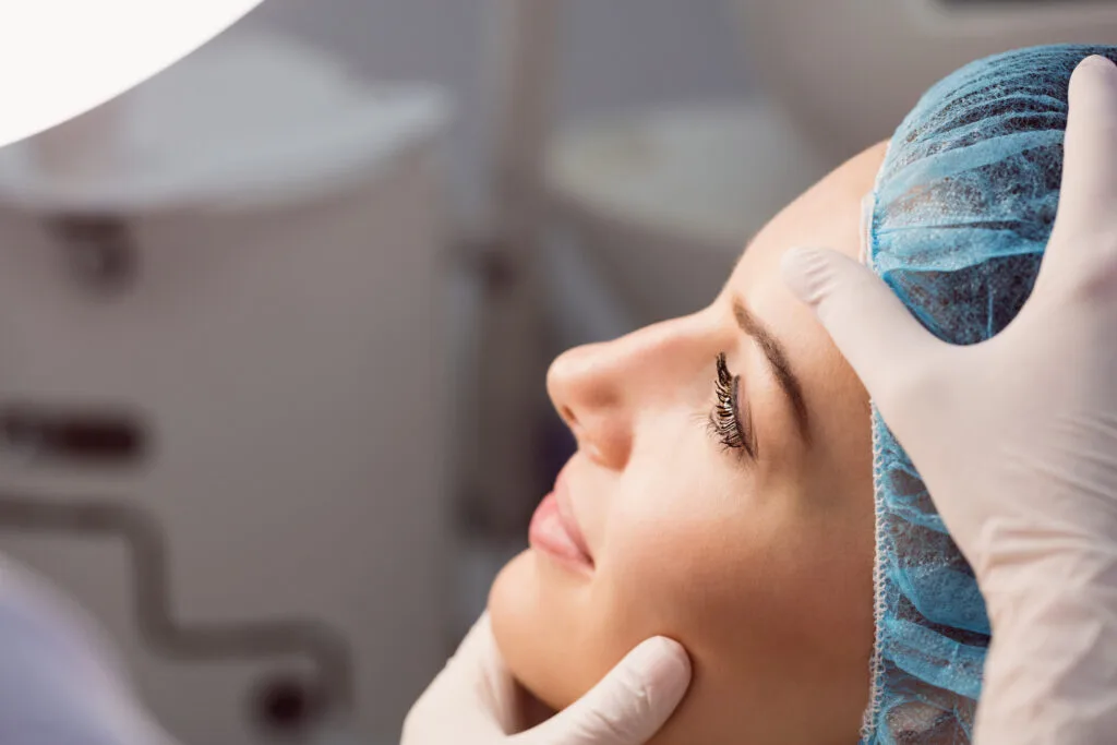 Especialista en oculoplastia examinando el rostro de una paciente antes de una cirugía de párpados
