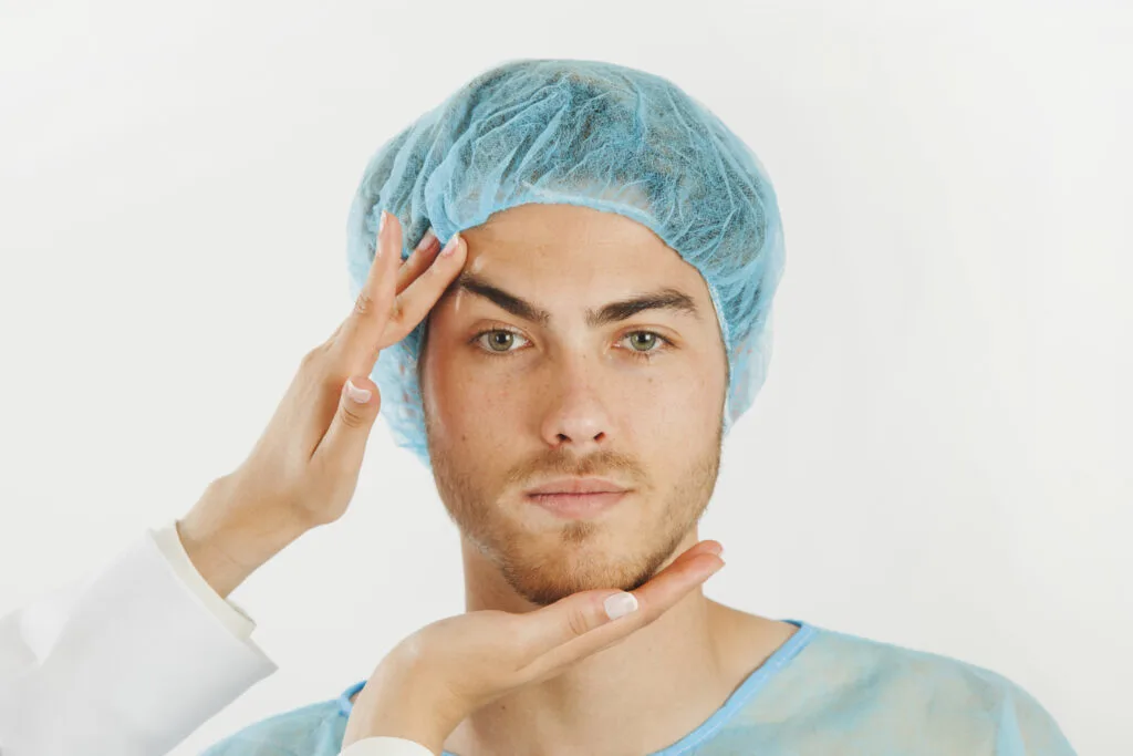 Cirujano examinando el rostro de un paciente antes de una blefaroplastia